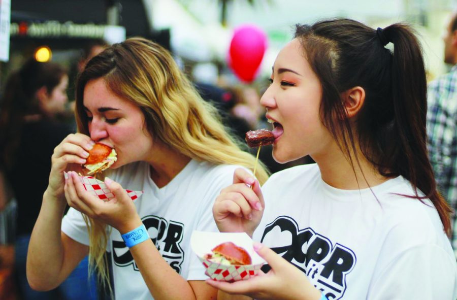 SAMPLING A TASTE OF BREA: Juniors Victoria Bell (left) and Kayla Gil (right) sample brownies and pulled pork sandwiches at Taste of Brea: Chasing Delicious on May 24.