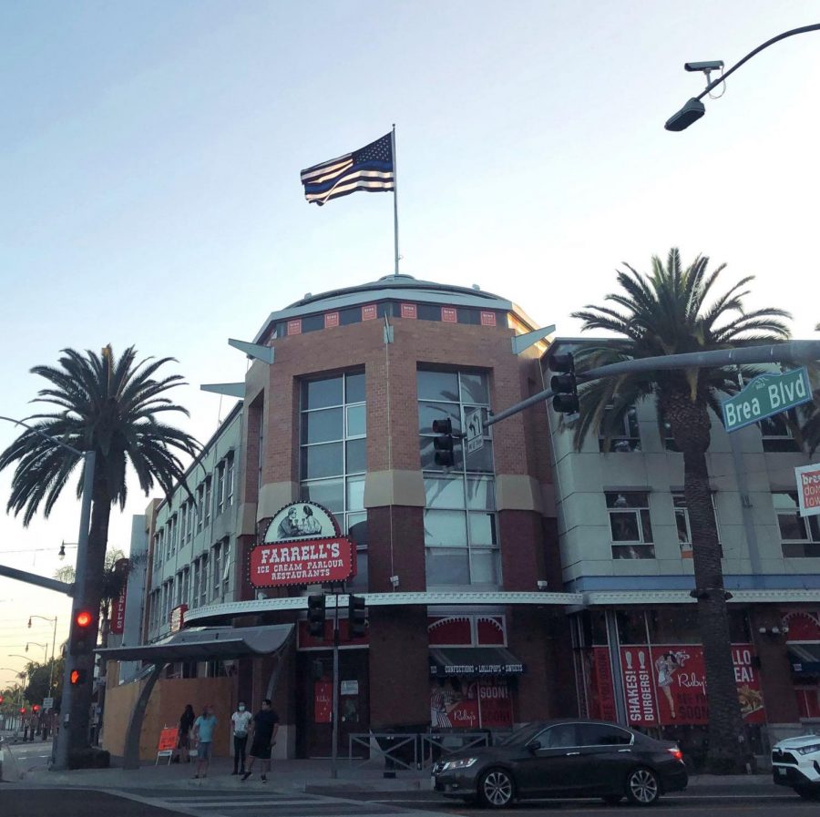 A Thin Blue Line flag towers above Downtown Brea. The flag, purchased by Brea resident and developer Dwight Manley ('84), sparked a debate in the community about the flag's connotations.   