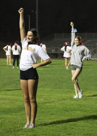 Emma Hidalgo, senior, and Peyton Lustyk, sophomore, practice a cheer during an Oct. 19 practice.