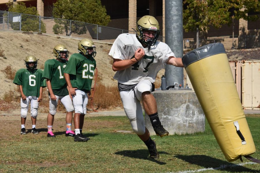 Brock LaBelle, senior, maneuvers around a tackling dummy at an Aug. 25 practice as teammates look on. Varsitys season opener was canceled this week due to COVID-19 protocols affecting Sonora High Schools ability to hold the required number of practices to compete. 