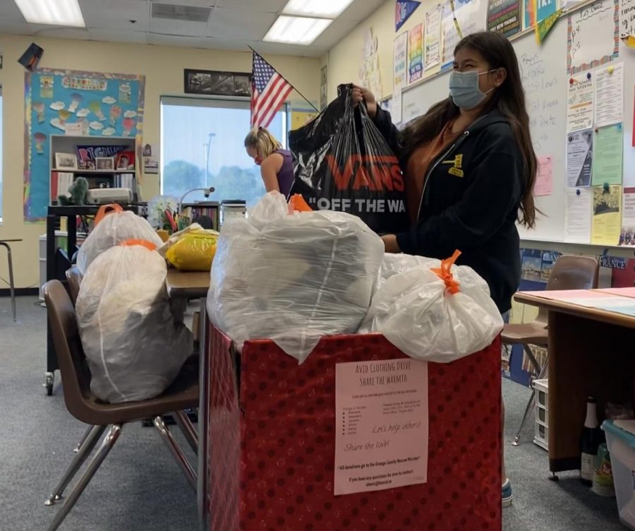 Samantha Hernandez, AVID junior, adds a bag of clothes to the designated AVID clothing drive box. The AVID clothing drive was held from Nov. 1 to Nov. 5, and all clothes donated went to the Orange County Rescue Mission in Tustin in time for the holidays.