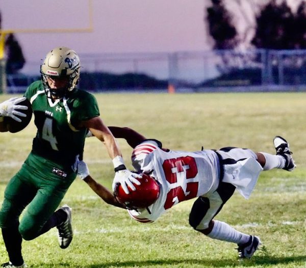 Nathan Aceves, junior, dismisses a Westminster High School defender during the Wildcats Aug. 18 non-league win. Aceves rushed for a game-high 130 yards. (Courtesy of Julie Marquez)