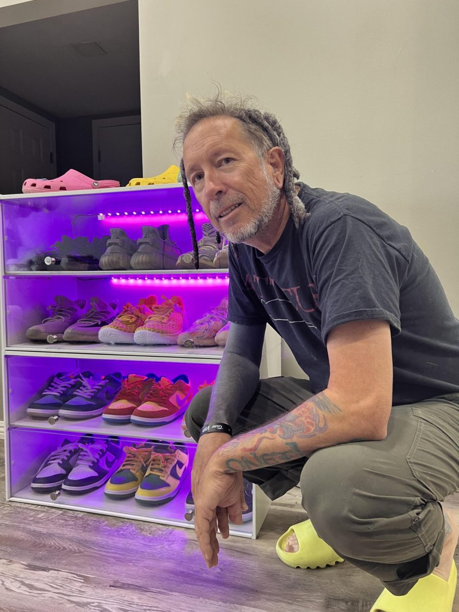 AP+Economics+and+Government+teacher+Stephen+Teal+in+front+of+an+LED-illuminated+display+of+his+shoe+collection.+Teals+fascination+with+colorful+kicks+started+in+the+third+grade.