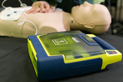 AED pads should be placed on the victim as compressions are being administered. This reduces interruptions where oxygen is not delivered to organs. 
