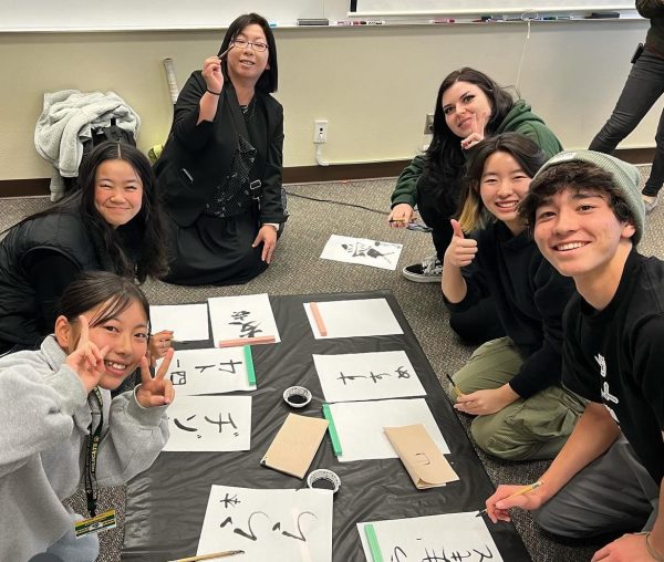 A Hanno student, teacher, and exchange representative guide BOHS juniors Katherine Dizon, Erin Kim, and Nikolaus Yamamoto in Japanese calligraphy. The activity was just one of many during the Hanno delegations week-long visit from Jan. 11 to 15. 