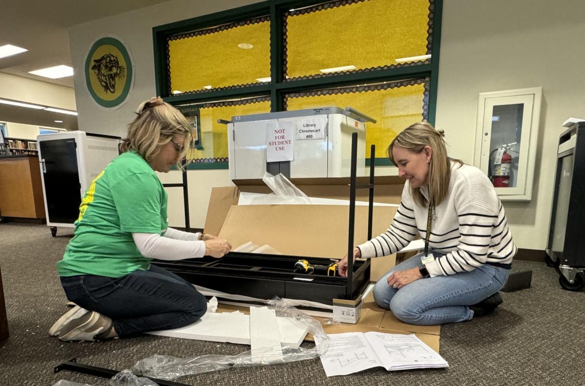 Nancy Bakunas, administrative assistant, and Diane Kaline, librarian assemble a table for room 200, which is currently being renovated into a WellSpace room. The room will provide sanctuary for students, and potentially staff, who are experiencing high stress and anxiety.  
