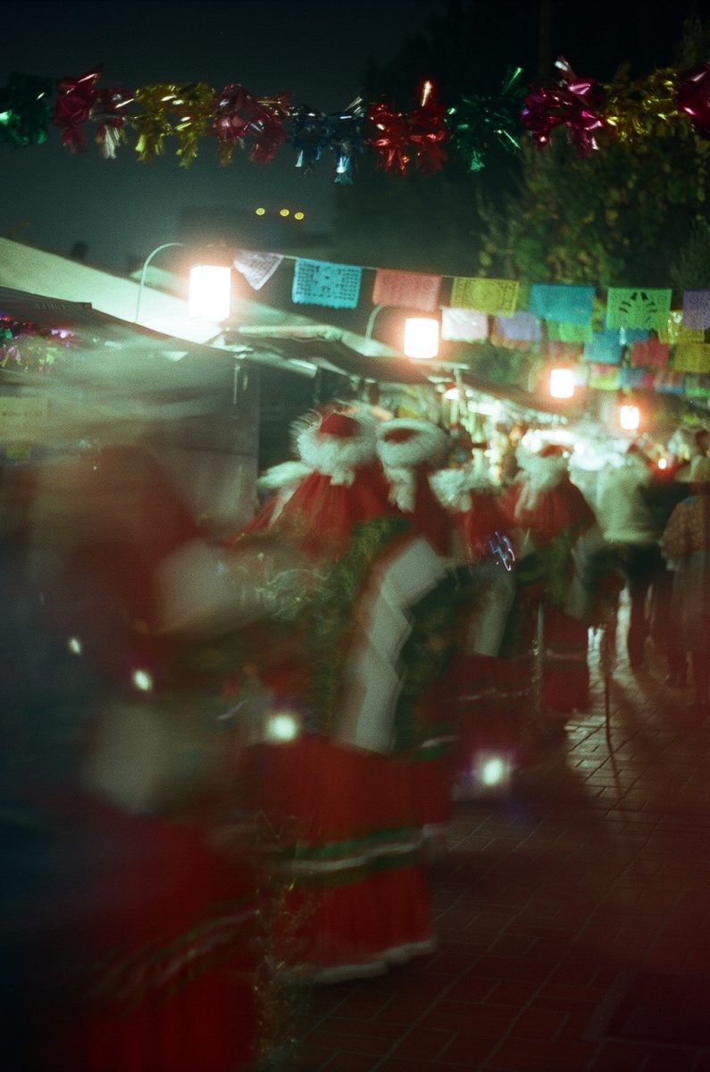 Women follow the procession of shepherds as they travel down Olvera Street. Every year, the Biblical story of Jesus's birth is re-enacted at Las Posadas.