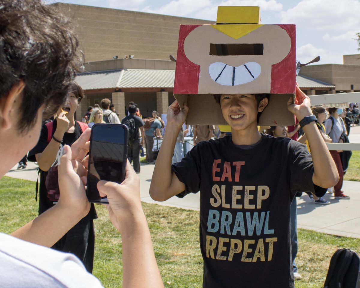 A student poses with a Brawl Stars "head" at the Brea Brawlers club table on Sept. 18.