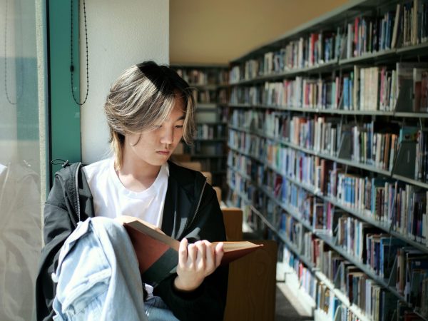 Dominic Lee reads in the BOHS library, which he says is the place that "best reflects his personality." Lee was named a National Merit Semifinalist on Sept. 11.