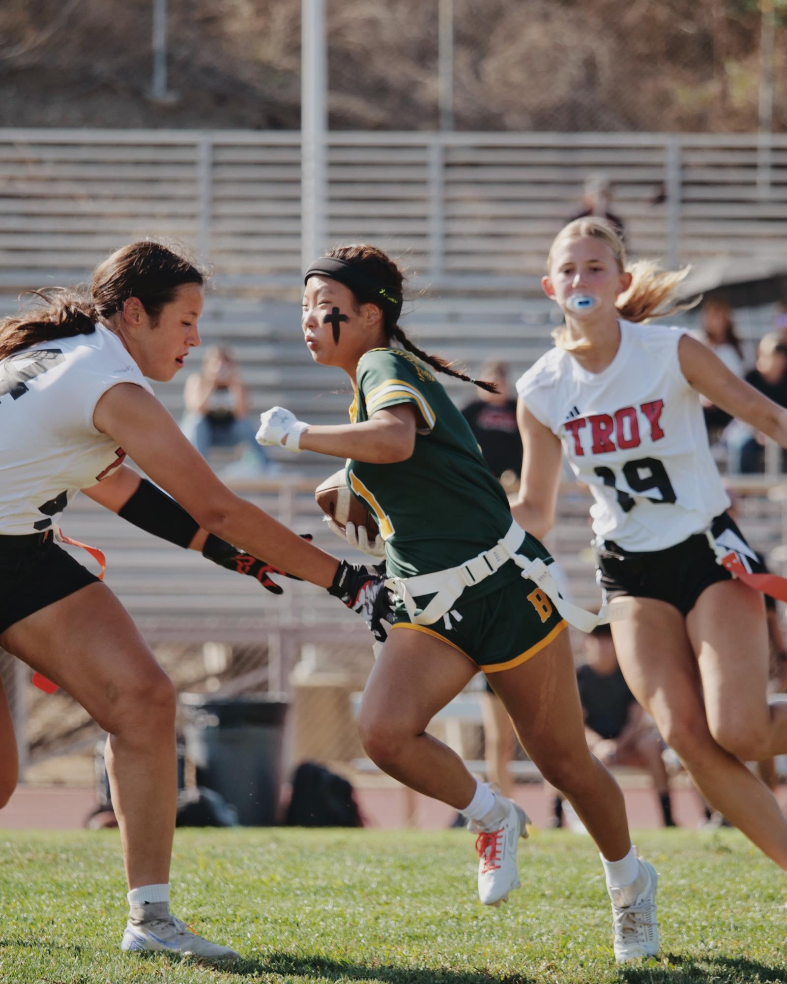 Hanee Park ('27) eludes a pair of Troy High School defenders on Sept. 25. The Wildcats fell behind 22-0 by halftime, but clawed their way to a pair of touchdowns for a 22-12 result. 