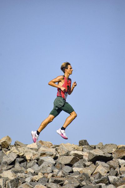 Varsity cross country runner Marius Nielson ('26) runs along "dam hill," a steep portion of the Carbon Canyon Regional Park course during the Brea Invitational on Oct. 5. (Courtesy of Demetri Garcia)