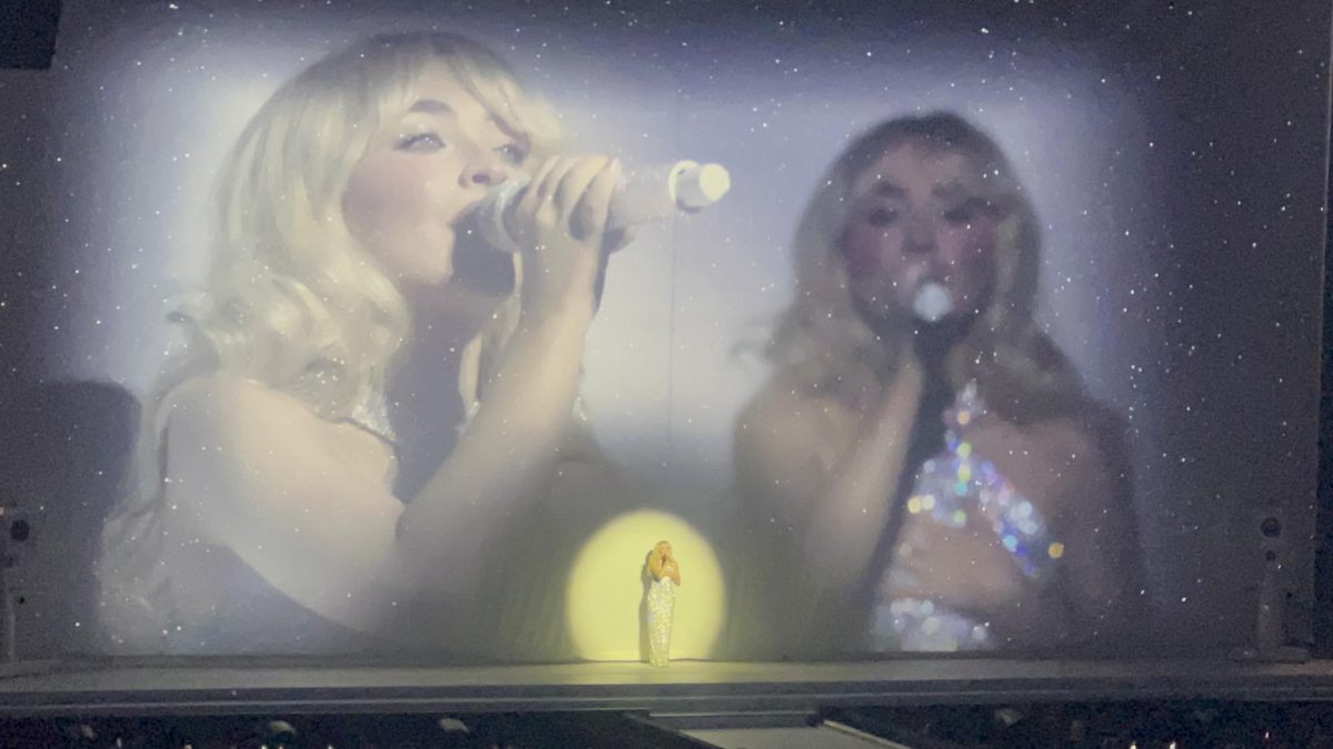 Sabrina Carpenter performs "Dumb and Poetic" while flanked by images of herself on the Kia Forum stage. The Nov. 15 show was the last of her U.S. tour leg, attracting over 70,000 fans to the stadium.