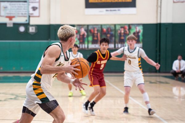 Carson Tracey ('26) looks to pass to Nick Chamberlain ('26) during boys' varsity basketball's 63-54 win over visiting El Modena High School. 