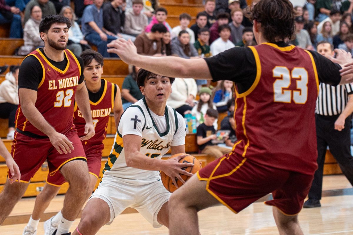 Tayag looks for an open teammate while being swarmed by El Modena defenders. 