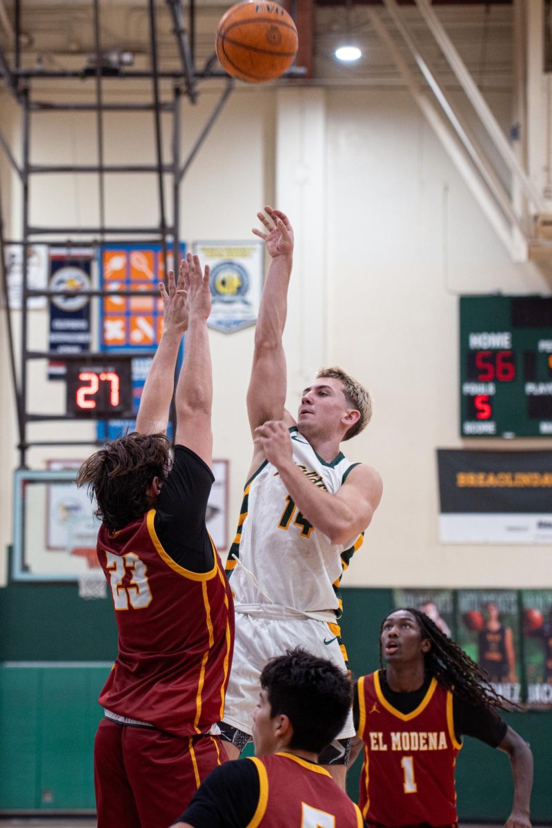 Tracey lifts a high-arching shot over the hands of an El Modena defender. Tracey  also knocked down two three-pointers and was 6 for 8 from the free throw line. 