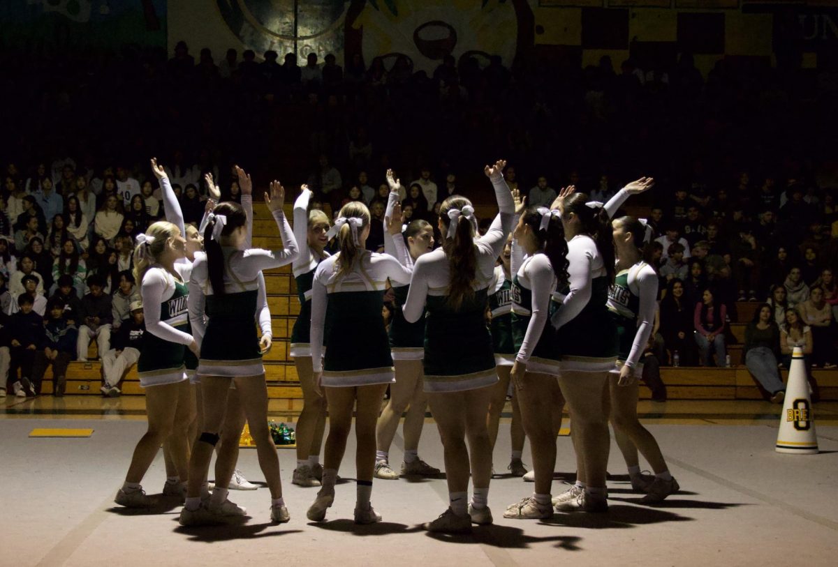 Varsity cheer huddles before performing their 2025 competition routine. 