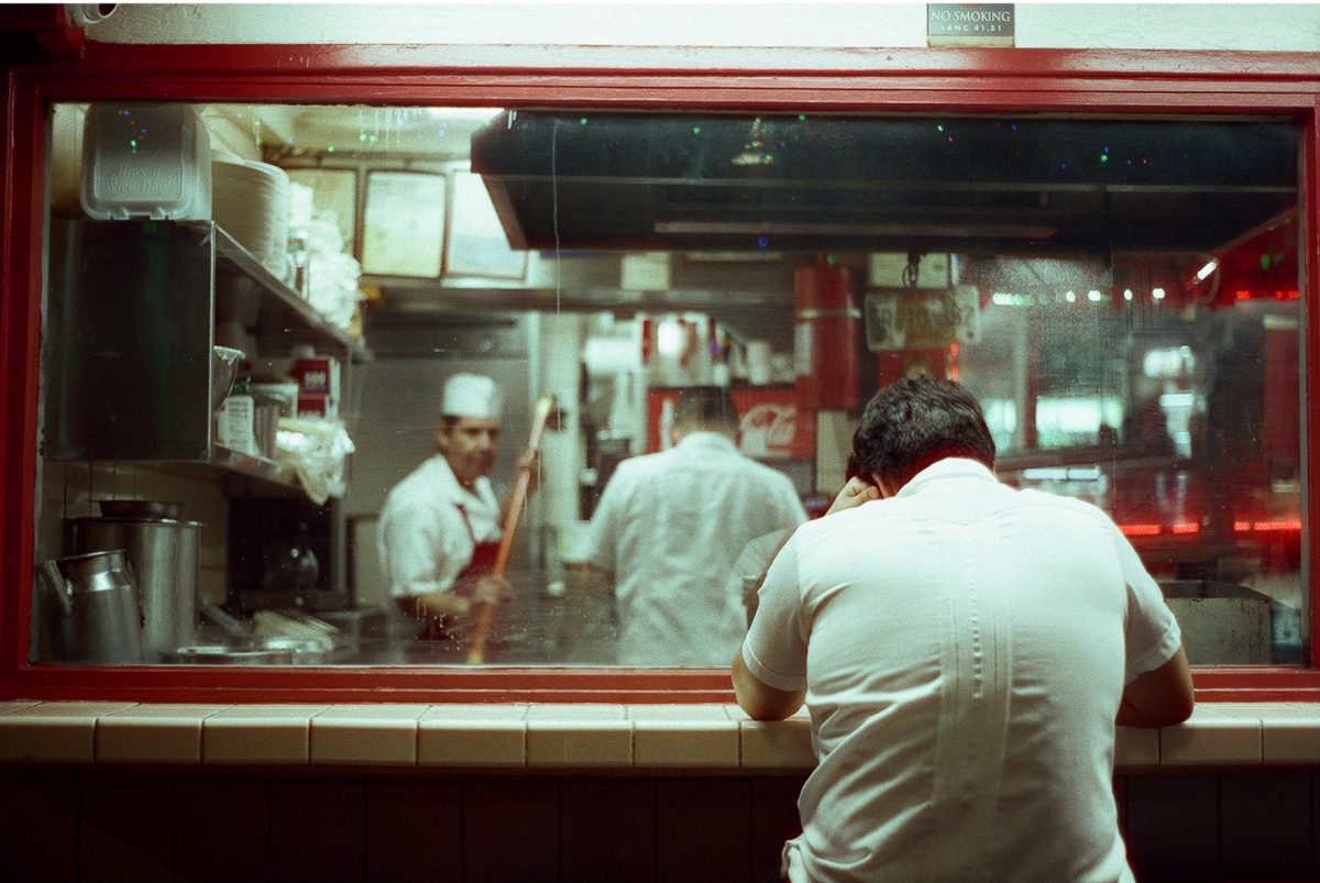 A man rests at a diner window at Los Angeles's Olvera Street Dec. 22. Photography With Analog Film Club (PAFC) gathers in local communities to shoot on film with analog cameras.