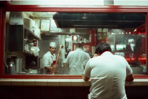 A man rests at a diner window at Los Angeles's Olvera Street Dec. 22. Photography With Analog Film Club (PAFC) gathers in local communities to shoot on film with analog cameras.