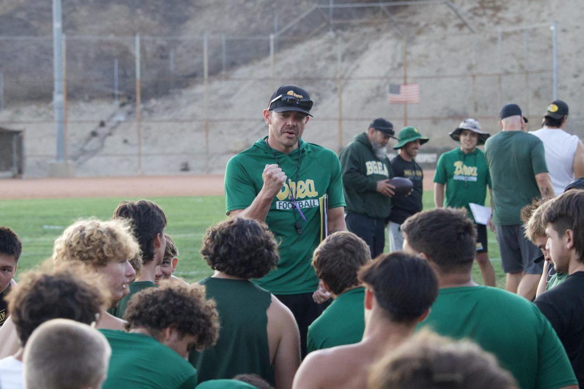 Varsity football fead coach Justin Villasenor talks to a group of players post-practice July 24.