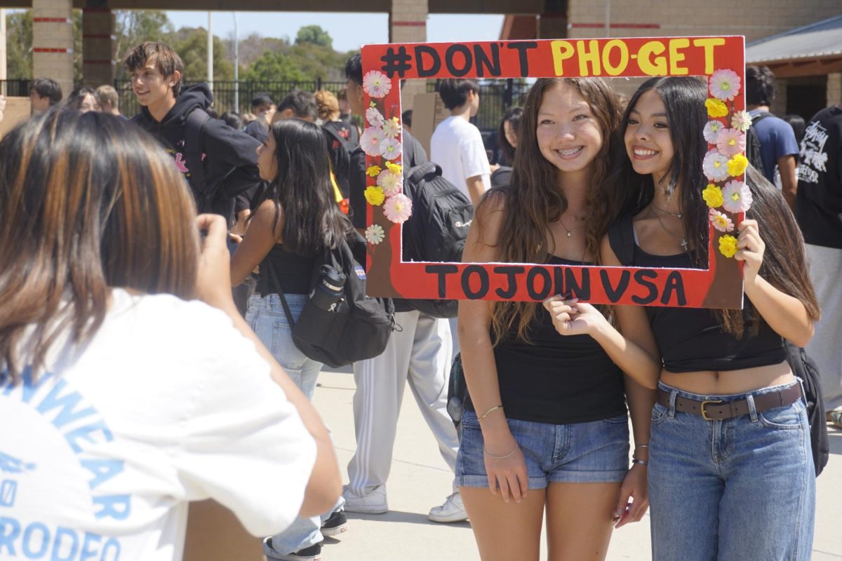 Krista Flowers ('28) and Claire Alejo ('28) enjoy a cutout from the Vietnamese Student Association in the quad during Club Rush's culture club day Sept. 11.