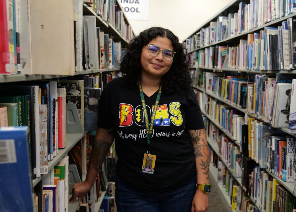 Josie Vasquez in the BOHS library. The Los Angeles native brings expertise in literature, film, and library and information science to Wildcat Way.