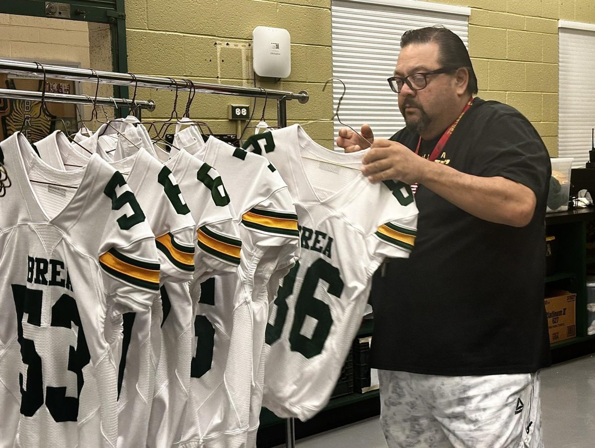 Zeke hangs clean jerseys on racks on Oct. 4, the morning after the Wildcats' away game at Westminster High School.