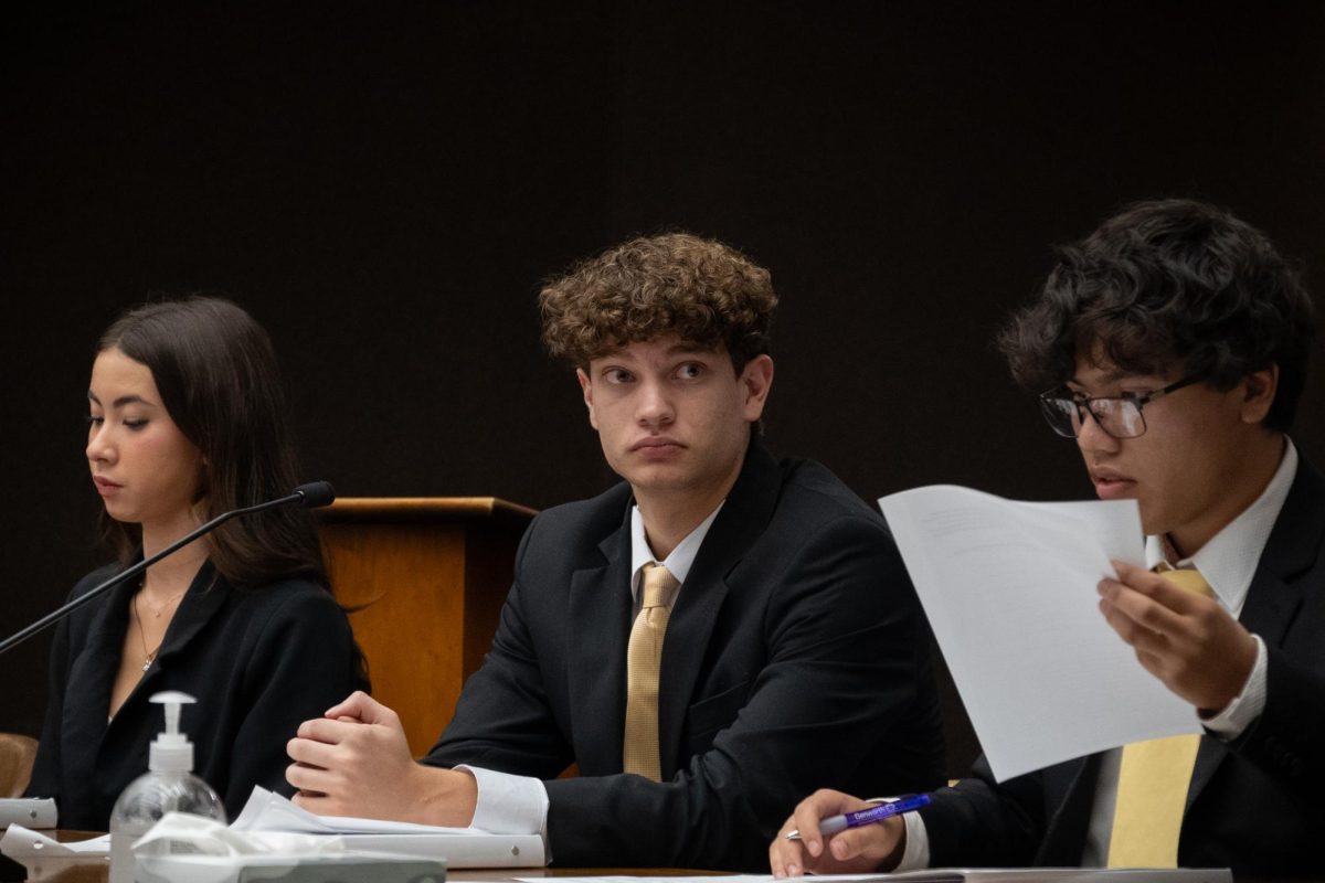 The competition, hosted by Teach Democracy (formerly known as the Constitutional Rights Foundation), features a fictional murder case where the prosecution must prove that the defendant killed a renowned chef by poisonous mushrooms. From left to right, Maia Hammel (‘27), Samuel Johnson (‘26), and Aiden Duenas (‘26) settle at counsel table as they prepare to present their arguments, Nov. 13.