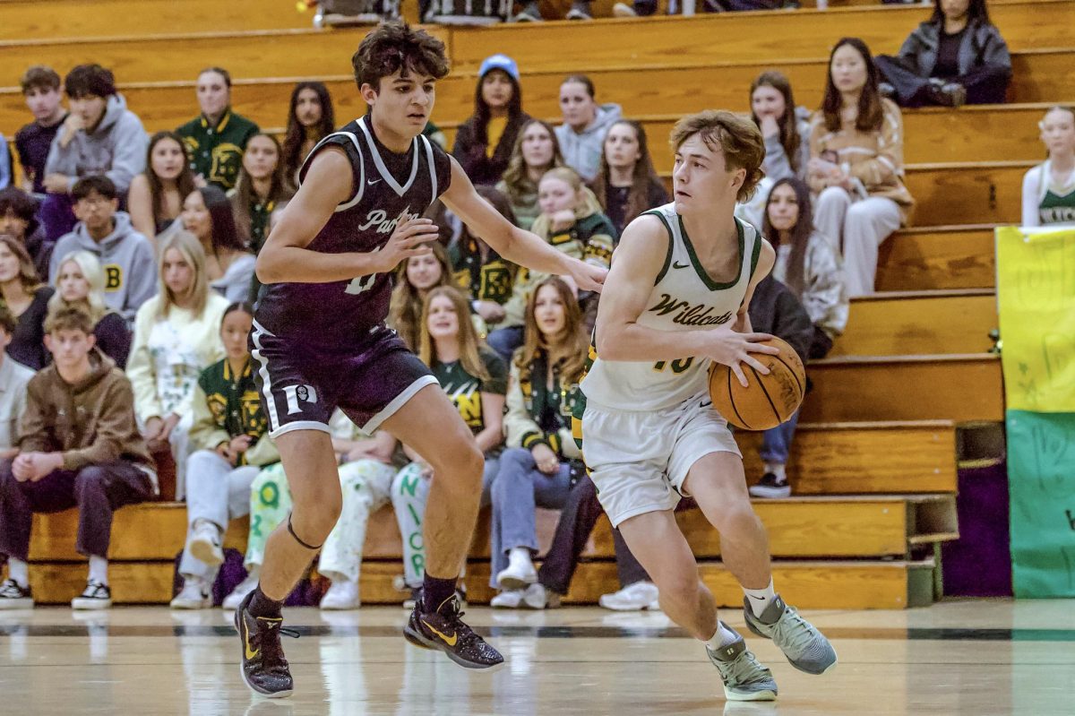 Brysen Byrnes ('26) looks for an open man during a baseline drive. Burns contributed eight points, all in the second quarter, and two steals in the winning effort. 