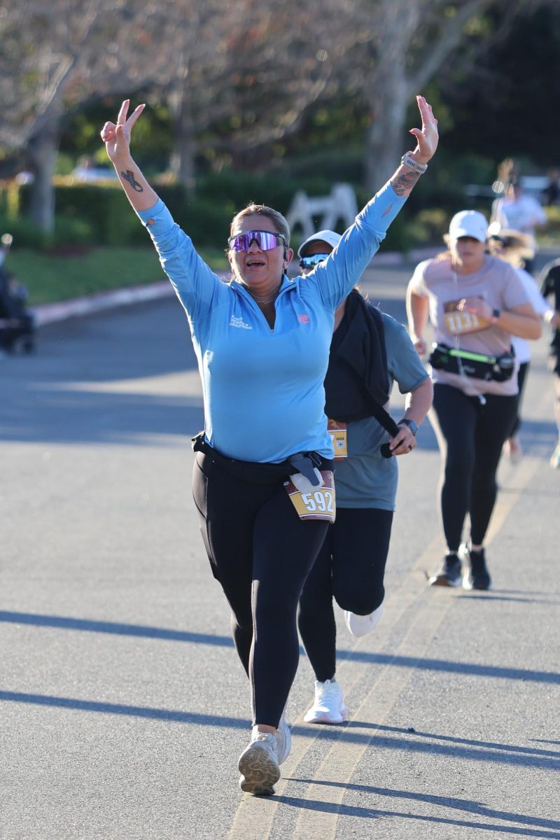 Brea 8K participant Marcella Almanza celebrates her completion of the race. 
