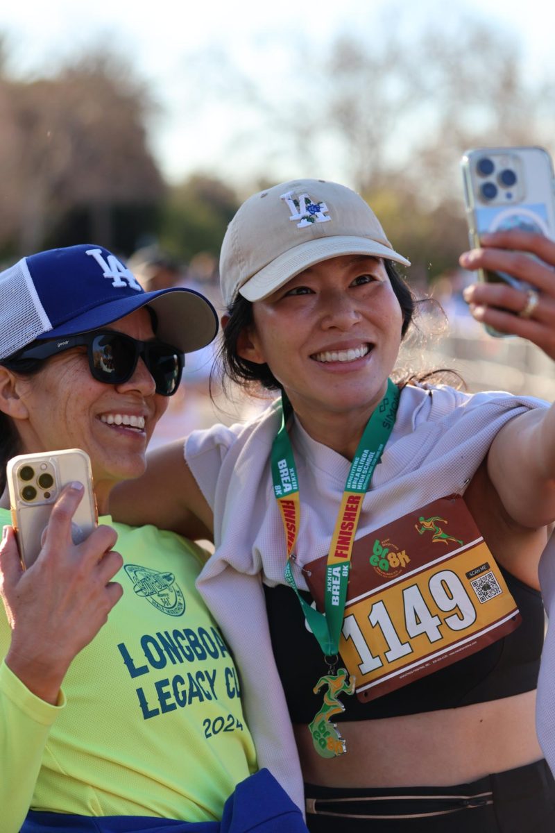 Brea 8K participant Jessica Cho takes a selfie with a friend after completing the race.