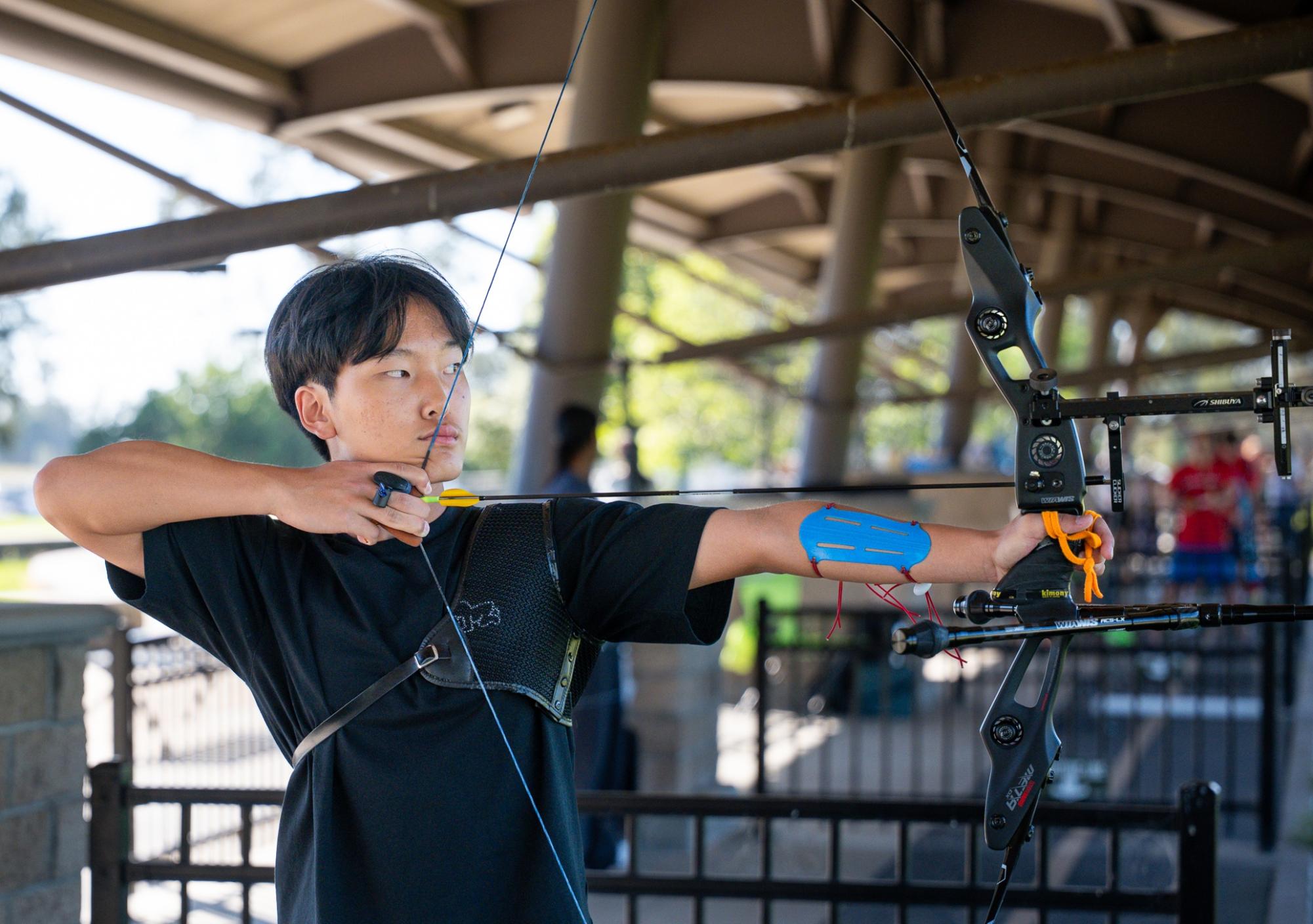 Zachary Lim ('28) draws his bow, aiming at a target. Lim is currently ranked 22nd in the U.S. in the under-18 male recurve division.